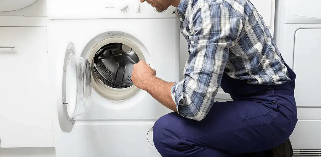 Handyman inspecting a dryer drum and internal parts for repair in Los Angeles, CA