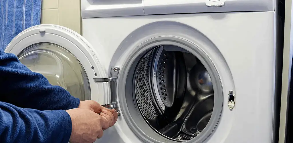 Washing machine repair handyman checking a front-load washer door and latch in Los Angeles, CA