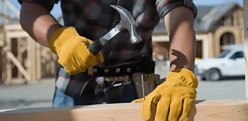 Handyman fixing wood trim with a hammer for home repairs in Los Angeles, CA