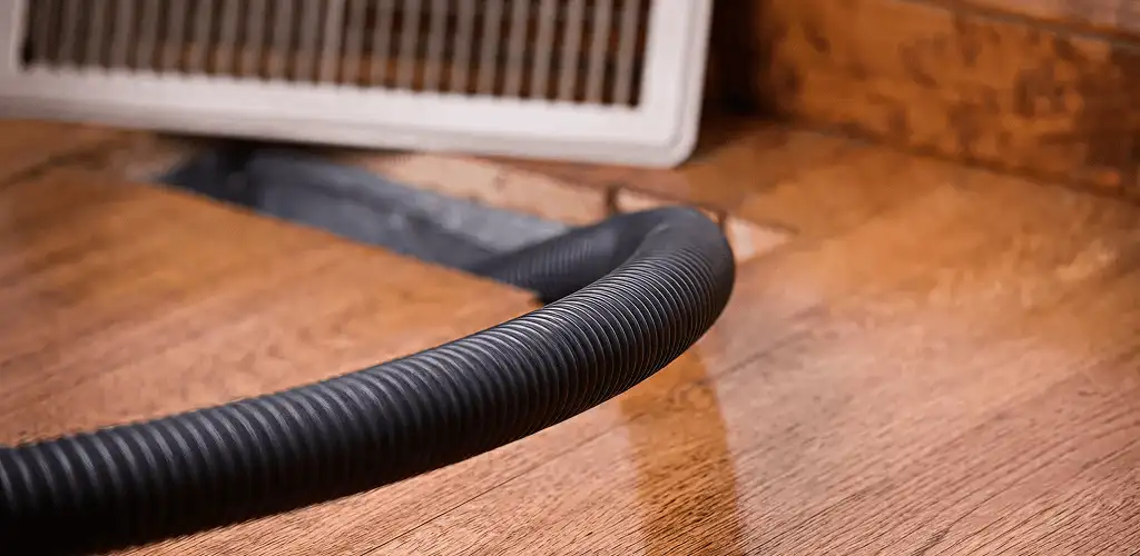 Air duct cleaning hose inserted into a floor vent for ductwork cleaning in Los Angeles, CA