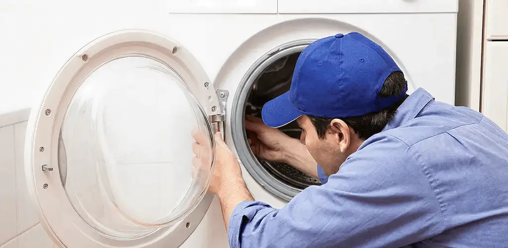 Washing machine repair handyman inspecting a front-load washer drum in Los Angeles, CA